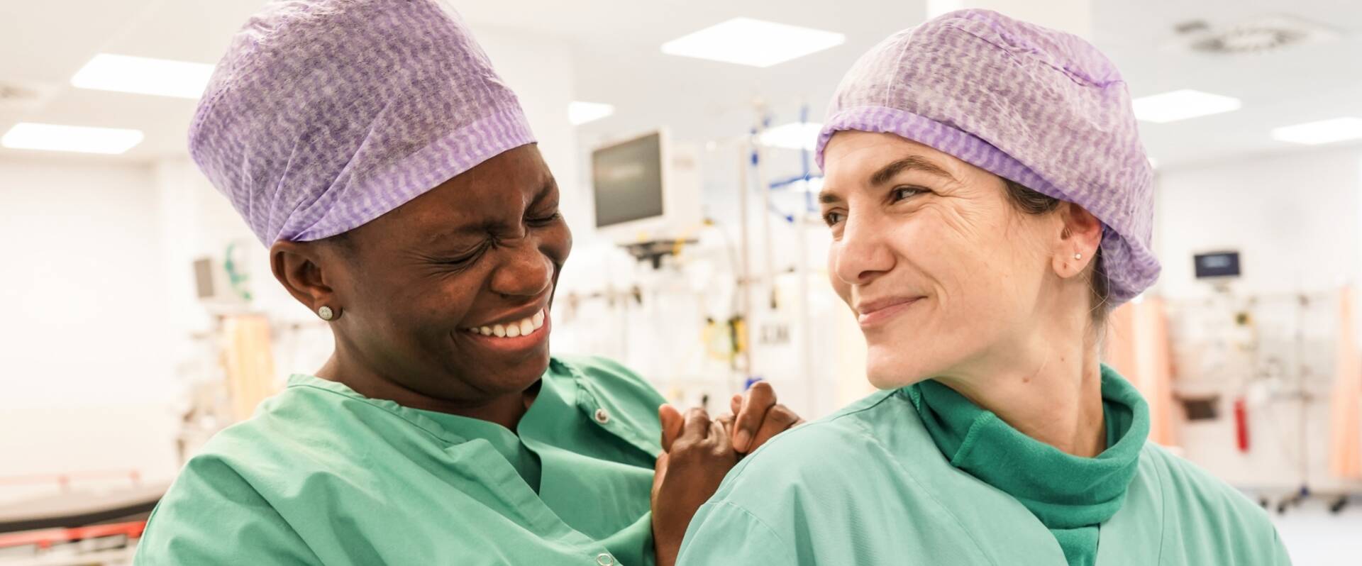Zwei glückliche Ärzte mit Haarnetz im Krankenhaus