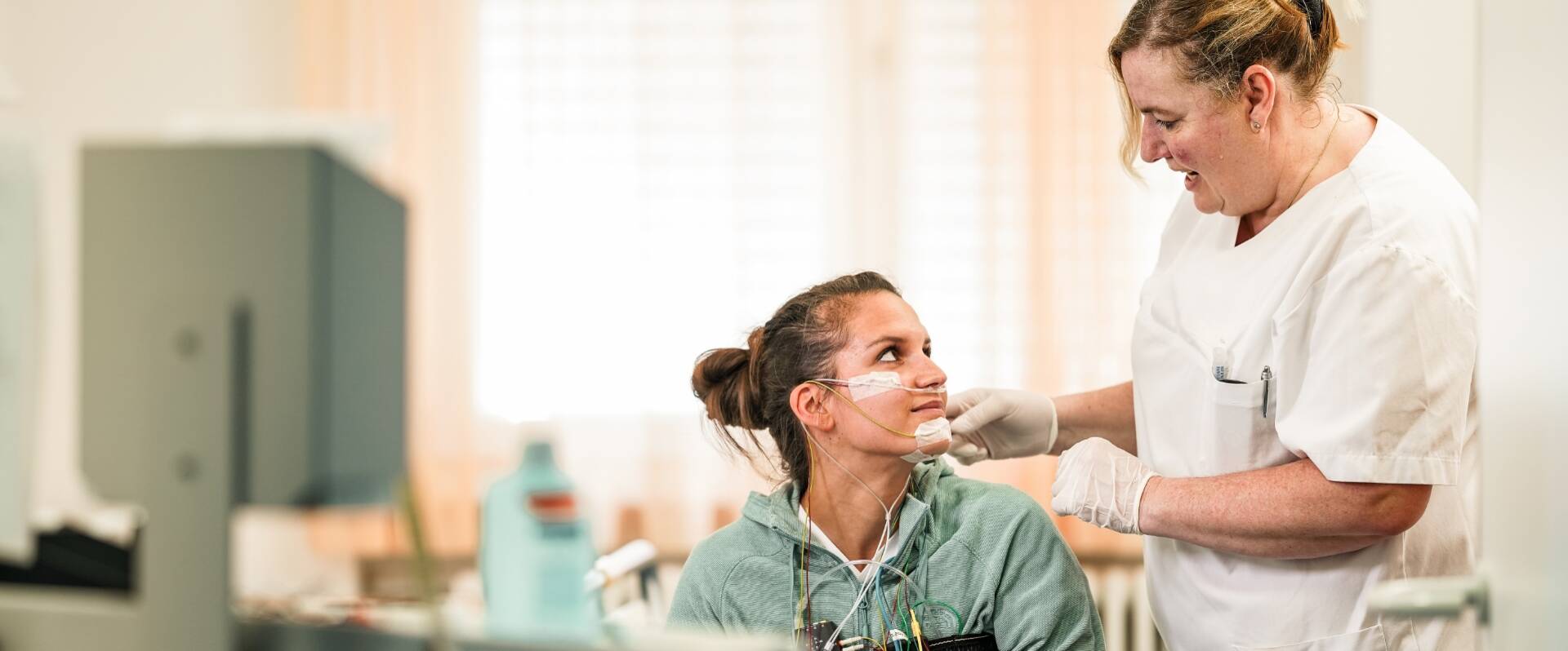 Patientin wird für Schlaflabor von einer Pflegerin verkabelt 