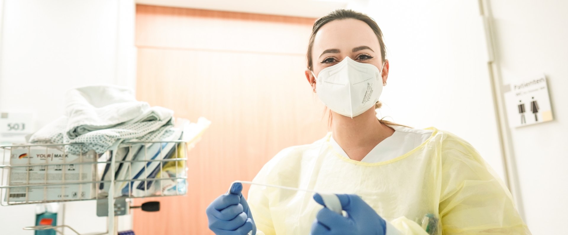 Ärztin mit Maske und Handschuhe im Krankenhausflur