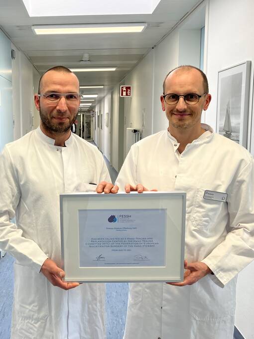 Freuen sich &uuml;ber die erneute Auszeichnung des Dachverbands der europ&auml;ischen handchirurgischen Gesellschaften: (v.l.) Dr. Eike Mrosek, Chefarzt der Unfallklinik Offenburg, und Dr. Wolf R&uuml;diger Warncke, Leiter der Sektion Handchirurgie. 