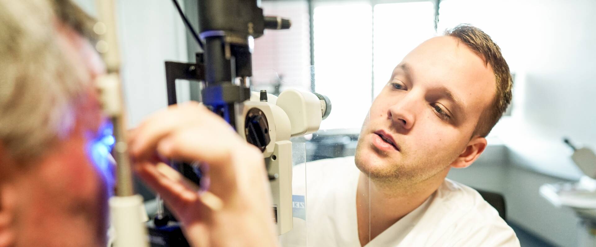 Junger Arzt nimmt Augeninnendruckmessung an einem Patienten vor