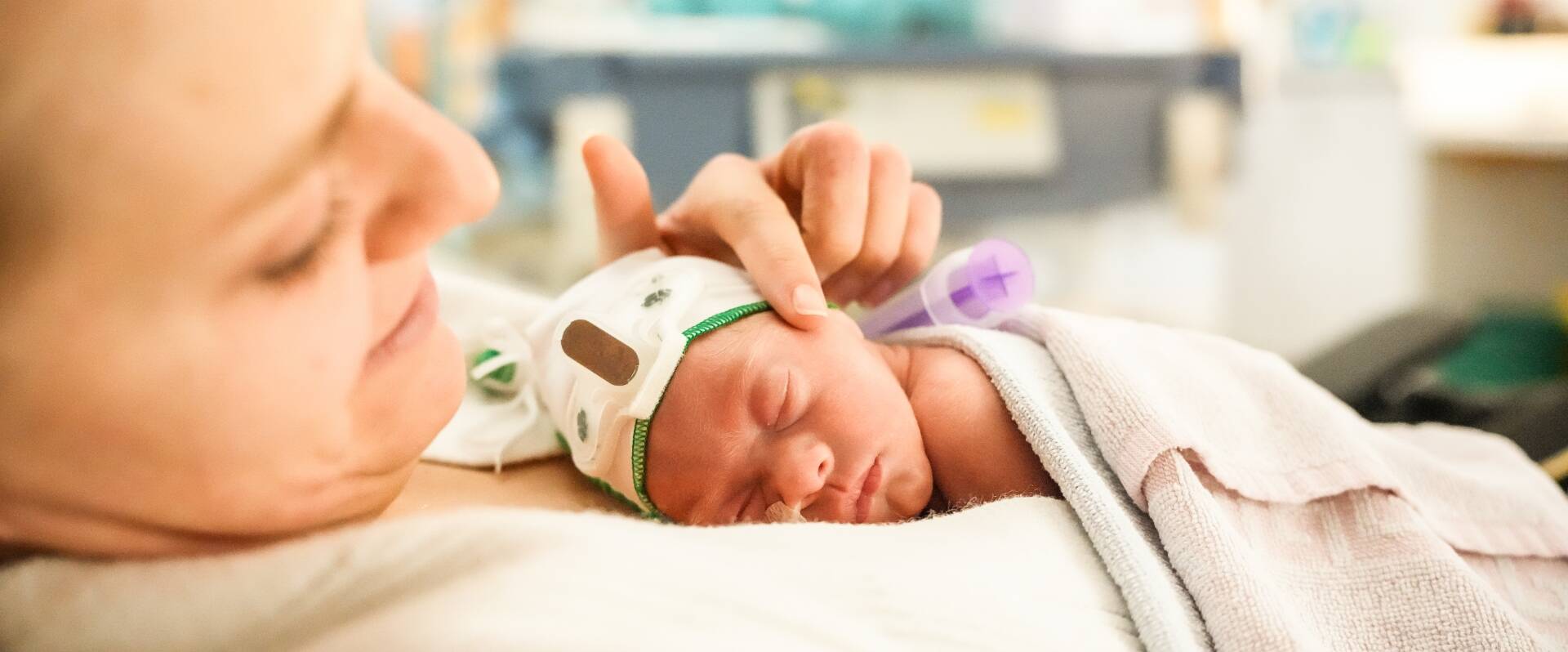 Neugeborenes Kind liegt auf dem Brustkorb der Mutter